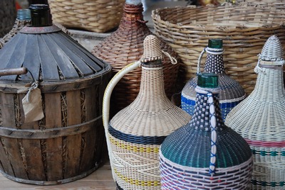 Kleine fles geweven in mand, gekleurd